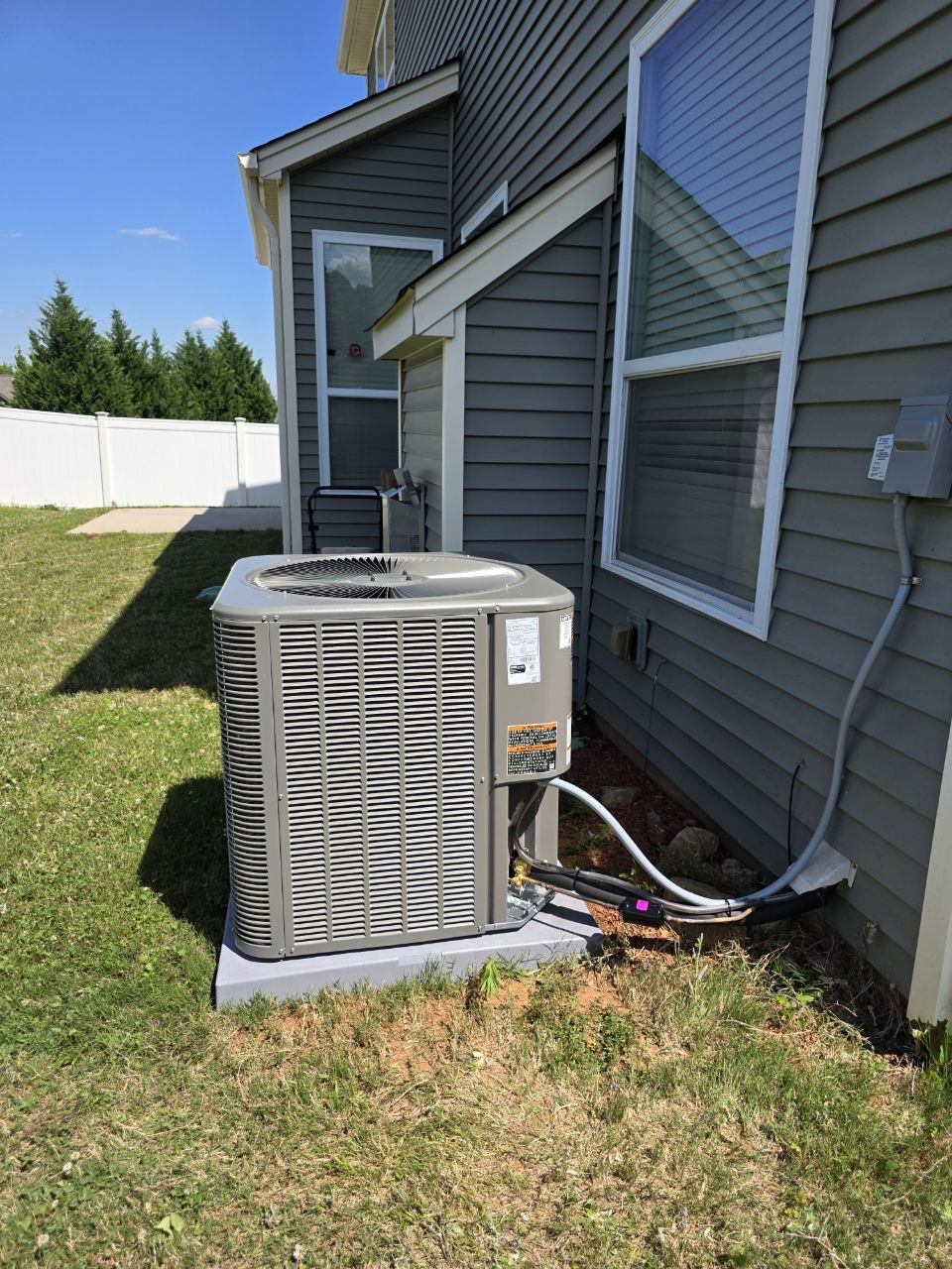 Outdoor AC system beside a home